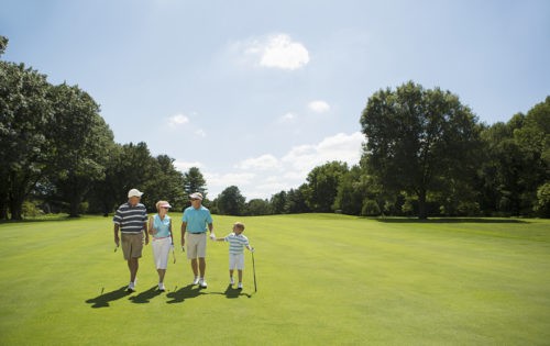 Family with boy (6-7) walking on golf course